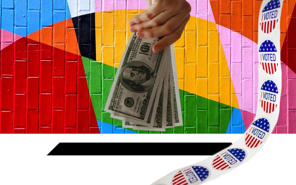 Hand holding 100 dollar bills, placing them into a ballot box. There is a roll of "I Voted" stickers on the side and a colorful brick background.