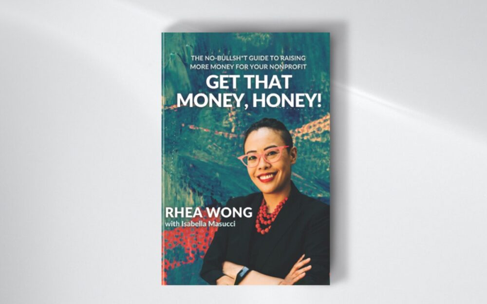 The interviewee’s book, “Get That Money, Honey!: The No-Bullsh*t Guide to Raising More Money for Your Nonprofit” lying on a white surface