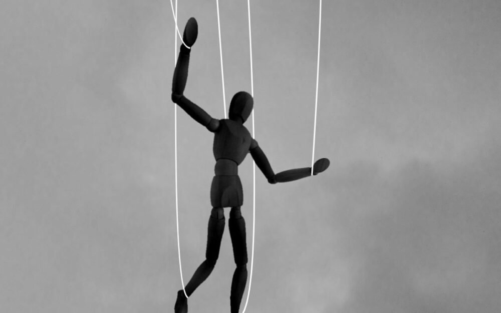 A drawing model figurine who is hoisted up on puppet strings, like a marionette