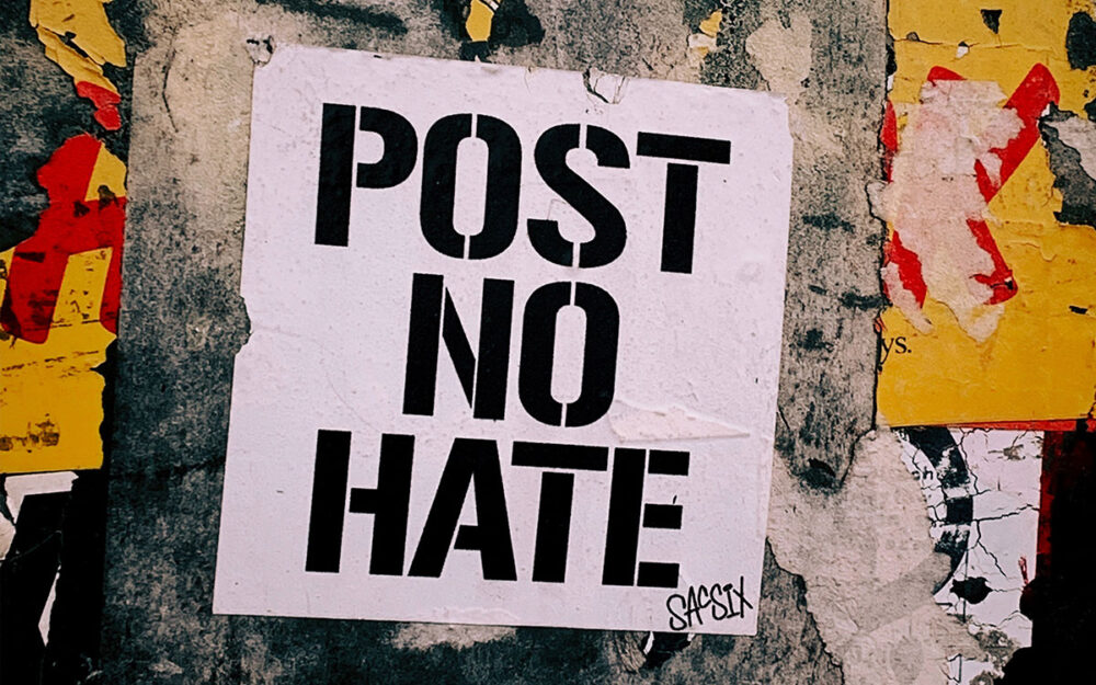 A poster plastered to a wall with the words, “Post No Hate” in bold letters