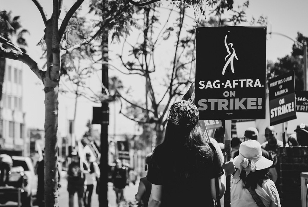 Black and White photo of Hollywood actors' union, SAG-AFTRA, standing shoulder to shoulder in a picket line with screenwriters, outside Amazon Studios in Los Angeles, California
