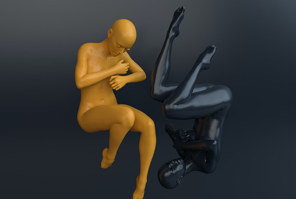 Two 3-D rendered mannequins, one yellow and one black, hugging themselves. They are upside-down in relation to one another.