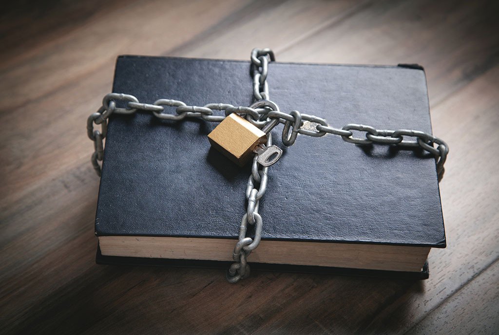 Black leather bound book with a chain and padlock around it.