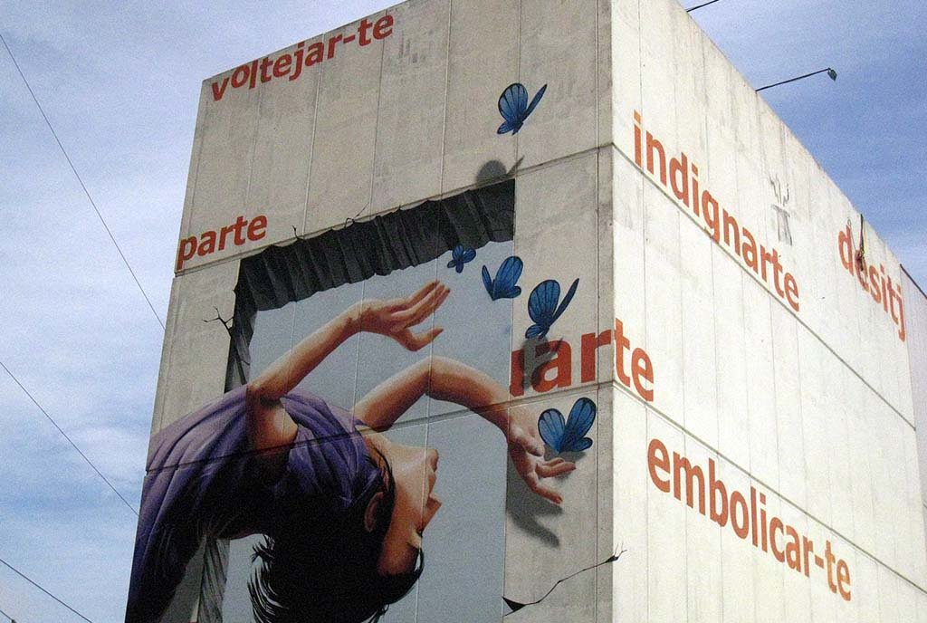 A graffiti image of a child dancing with butterflies on the exterior wall of 165 Ateneu Popular de Nou Barris, Barcelona, Spain.