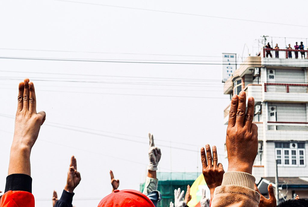 A group of protestors in Myitkyina, Myanmar (Burma) holding up the three-finger salute, a Southeast Asian symbol of pro-democracy and defiance against tyranny.