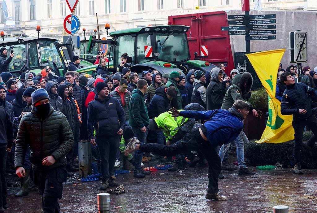 A Belgian farmer throws eggs towards police officers in protest over green regulation while other farmers use their tractors to block the European Parliament. Brussels, Belgium February 1, 2024