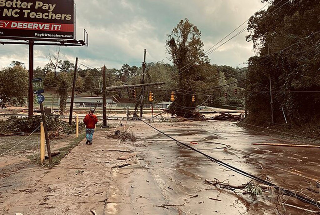 Devastated street with downed trees, powerlines, and flooding in Asheville, North Carolina. This Appalachian city was hit hard by Hurricane Helene.