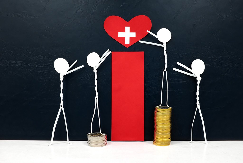 Four stick figures reaching for a red heart shape with healthcare cross cutout, while stepping on stacks of coins of various heights, symbolizing cost’s role in access to healthcare.