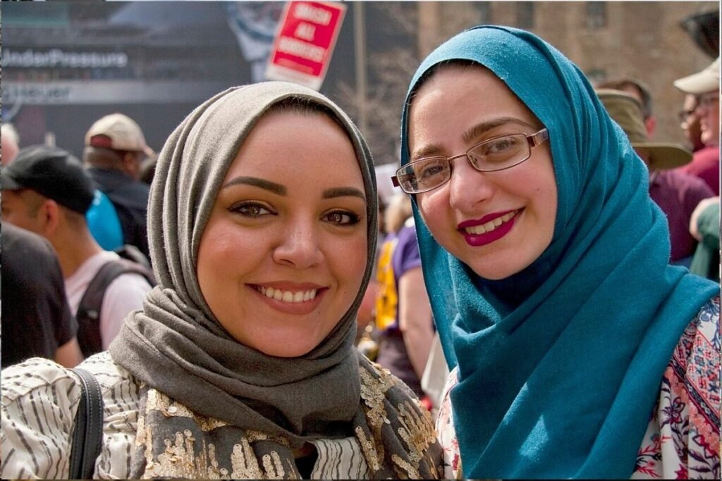 Two Muslim women wearing head scarves who are participating in a May Day labor rally in Chicago, Illinois pose for the photographer.