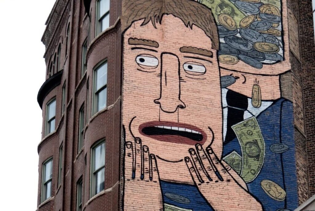 A mural shows a frightened man with eyes open, hands on his chin, and dollars and coins slipping through his fingers.