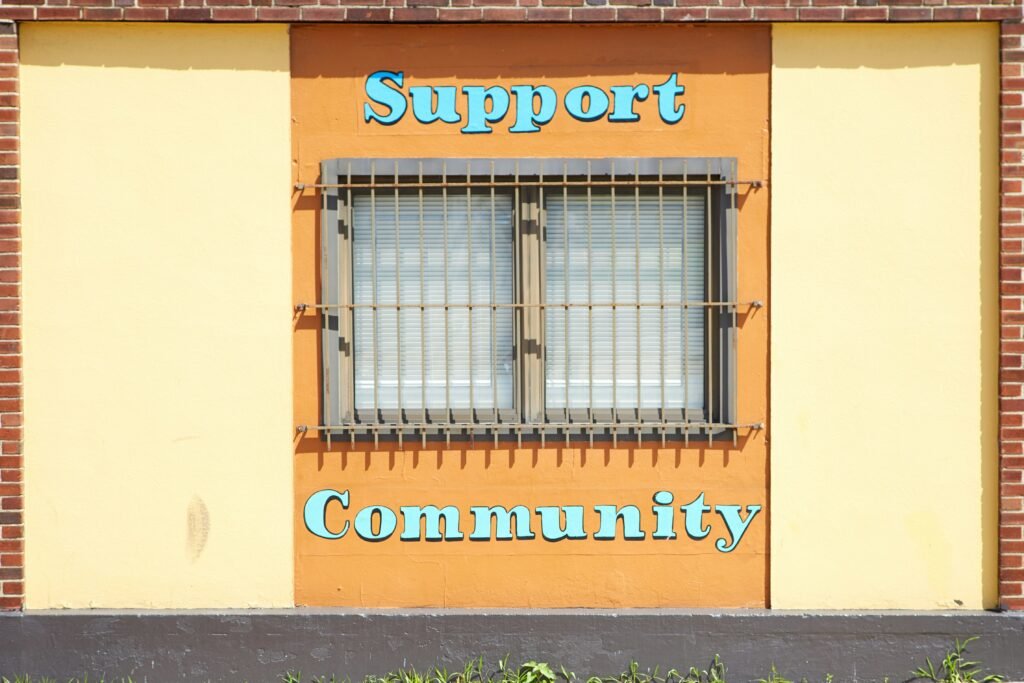 A building with the message of ‘support’ and ‘community’ around the steel bar window.