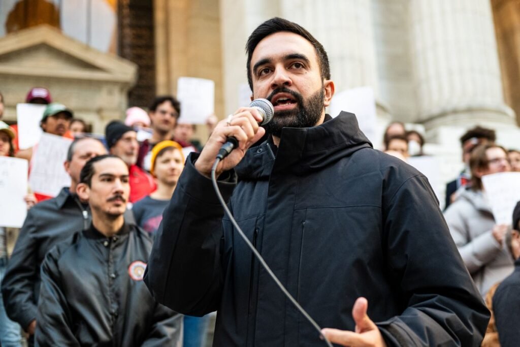 Wearing a black jacket, Zohran Mandani speaks in front of a crowd at Bryant Park in Manhattan at a rally to resist fascism.