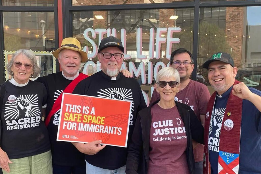 CLUE activists posing together holding a sign that reads, "This is a safe space for immigrants."
