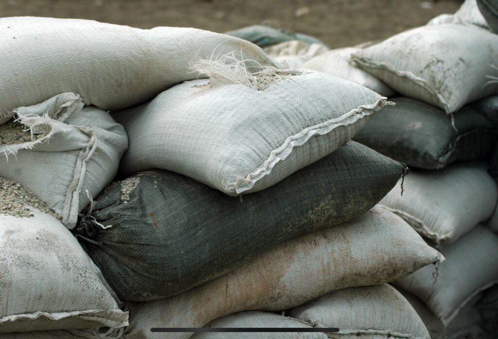 a pile of sandbags, used to mitigate flooding. Metaphor for the strategy necessary to combat “flood the zone” tactics.