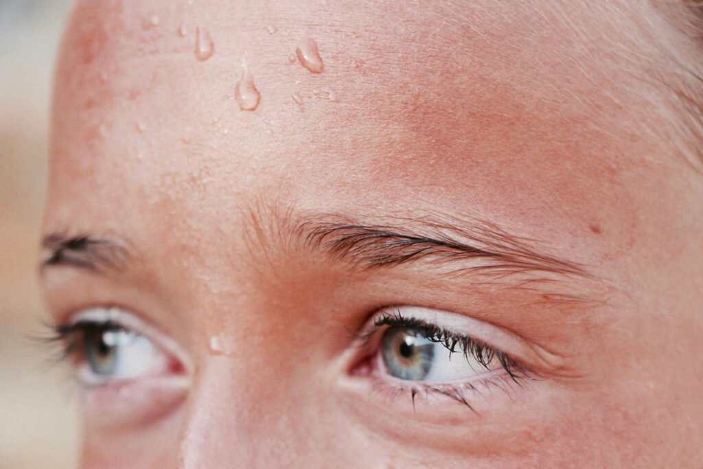 A close-up of a young student with beads of sweat on his forehead.