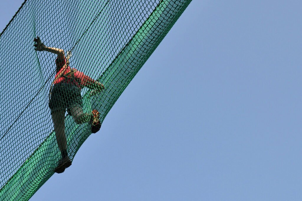 A person walking overhead in the protection of a safety net, symbolizing how fiscal sponsors can serve as a safety net for movement groups.