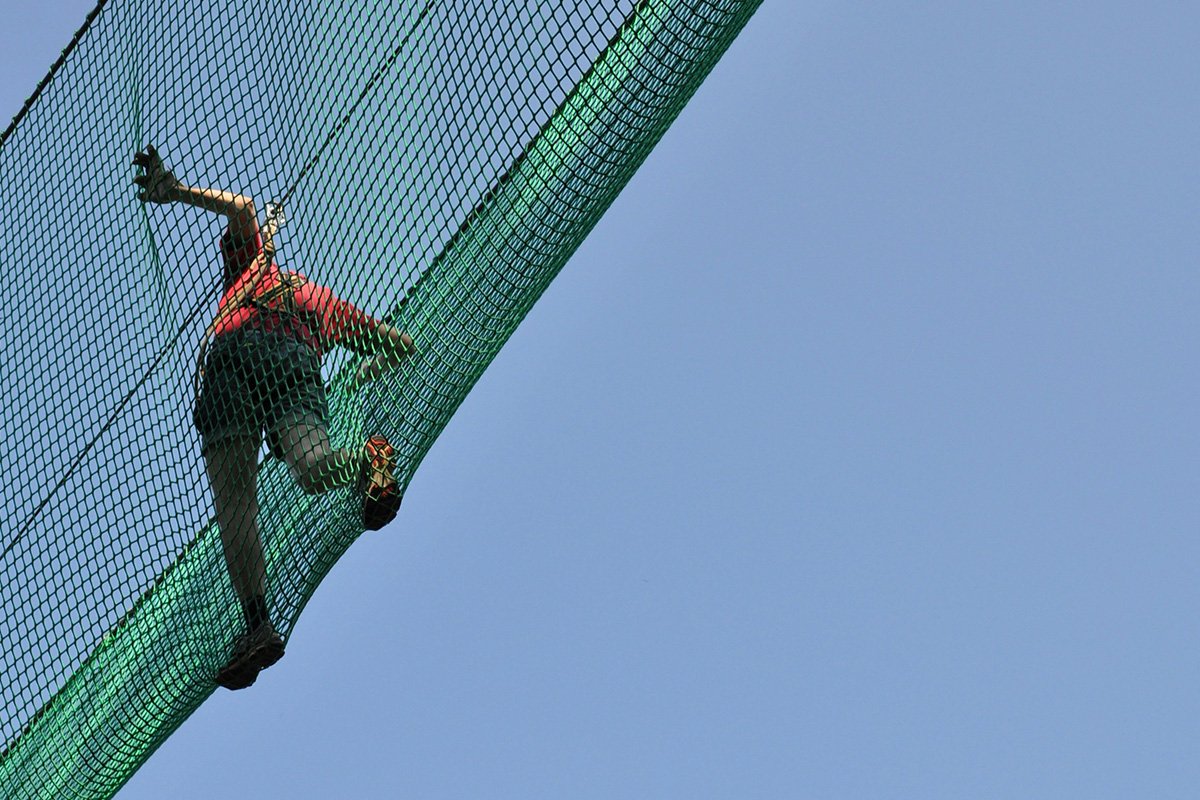 A person walking overhead in the protection of a safety net, symbolizing how fiscal sponsors can serve as a safety net for movement groups.