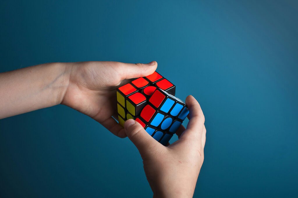 A person about to solve a rubiks cube, echoing the need for real, transformative solutions.