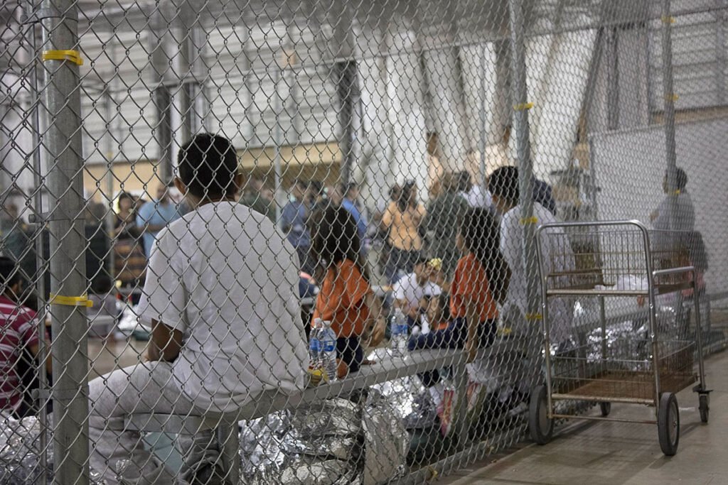 ICE detainees sitting in caged cells in Ursula detention facility in McAllen, Texas.