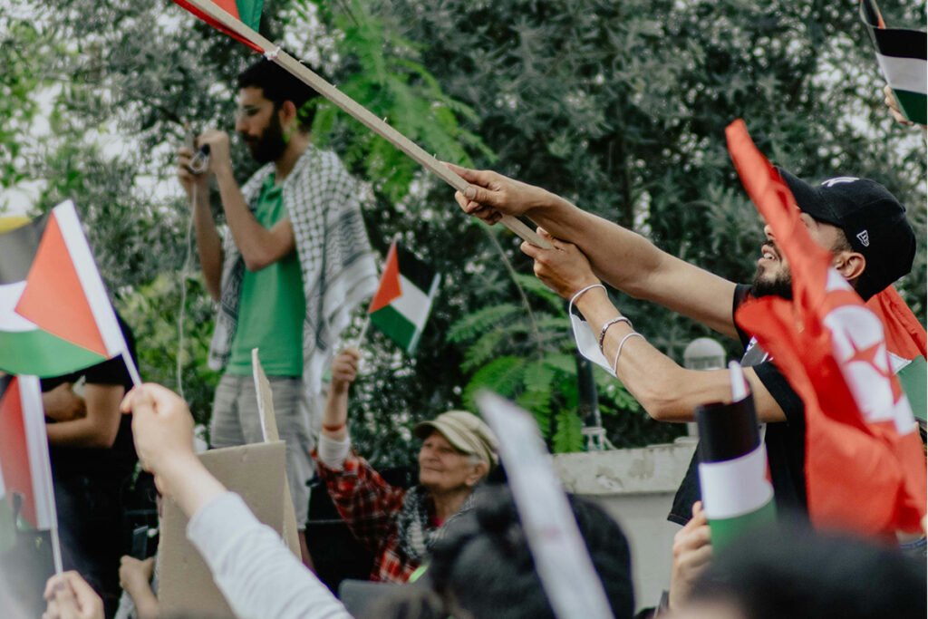 A group of people boldly showing support for Palestinians and waving the Palestinian flag.