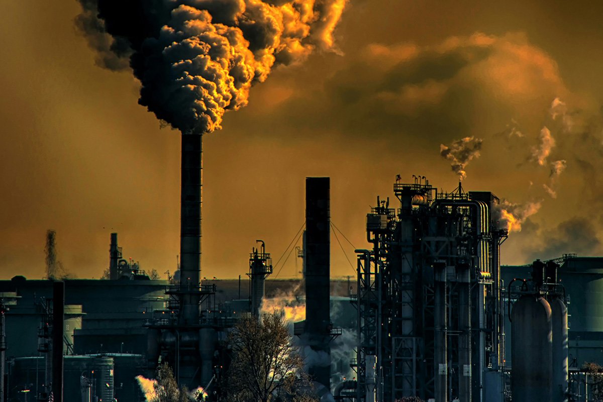 A coal burning power plant pluming smoke, representing fossil fuel burning that has caused increased levels of greenhouse gases in the atmosphere.