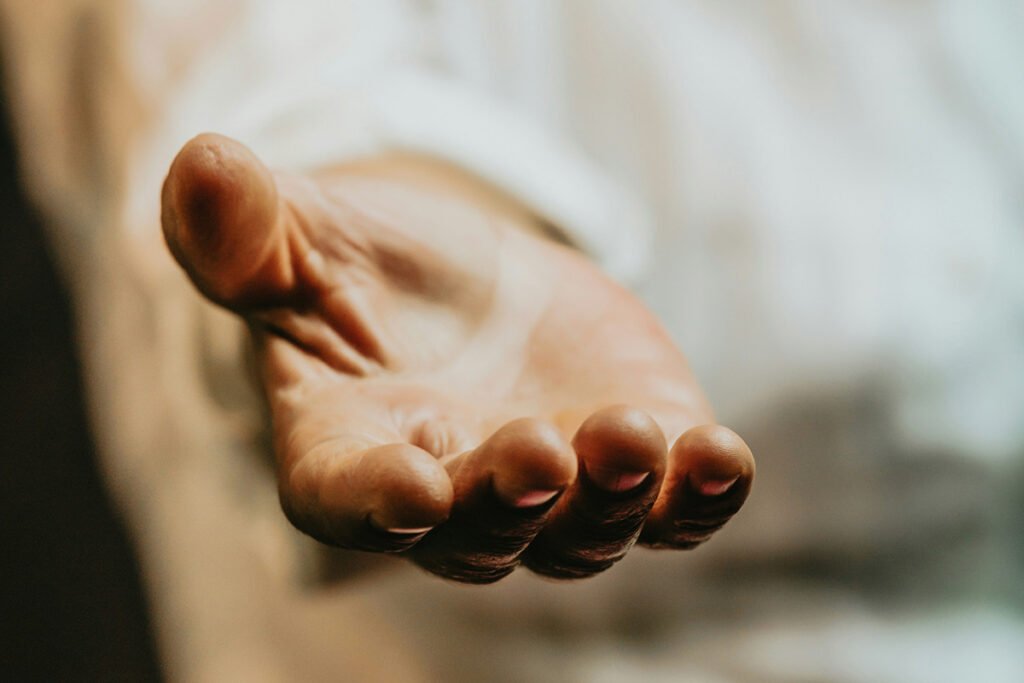 A close-up of a welcoming, outstretched hand, symbolizing the care and support offered in the solidarity economy.