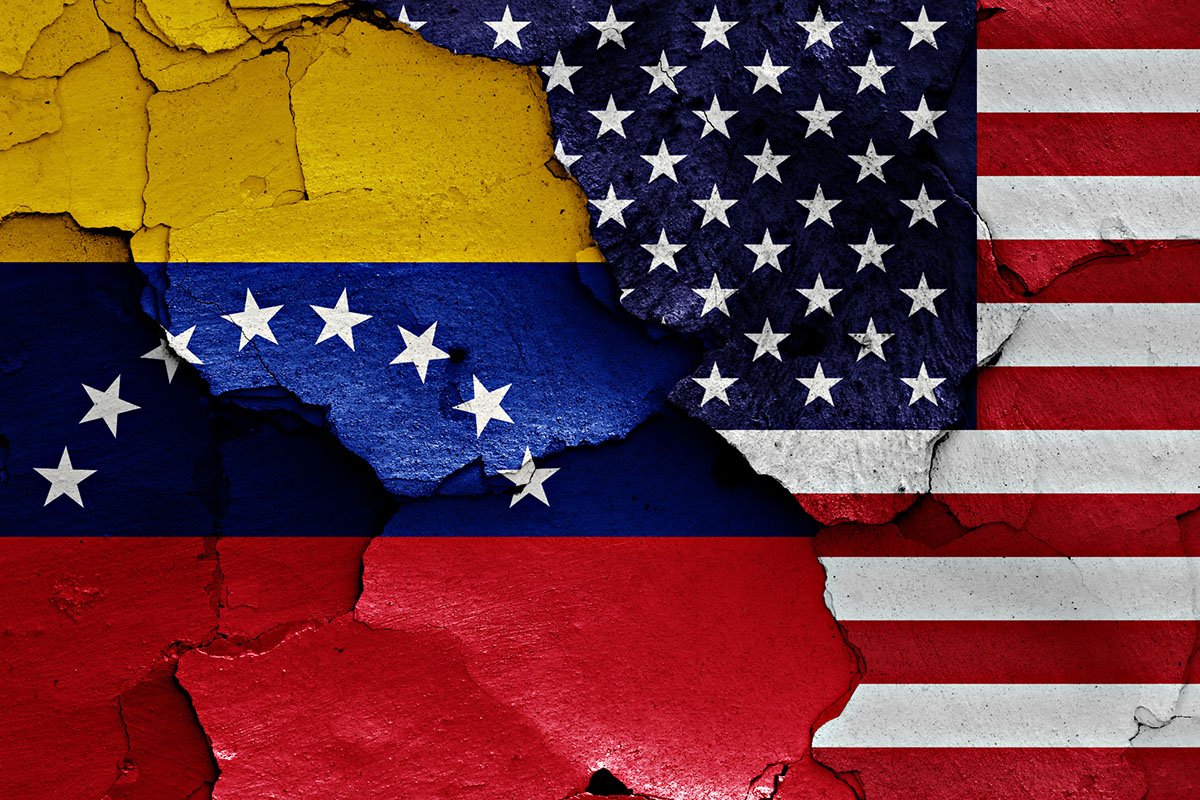 The flags of Venezuela and the United States of America painted onto a cracked wall, symbolizing the fractured future of TPS Venzuelans in the US.