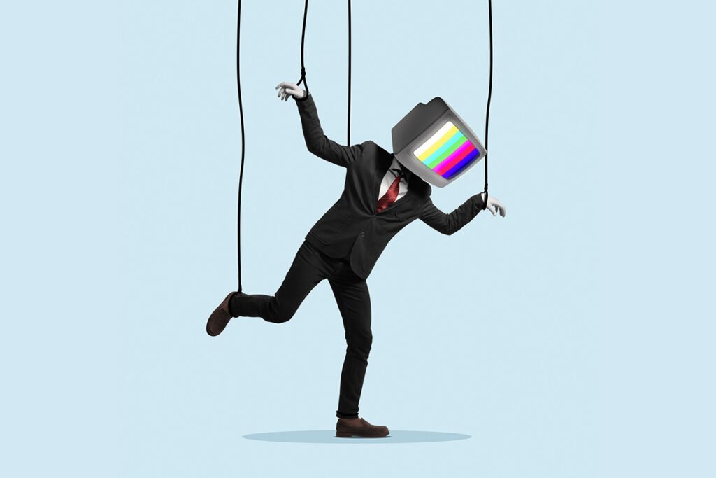 A man in a business suit with a television for a head, his arms and legs are being controlled by puppet strings.