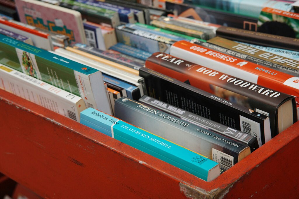 A closeup shot of a bin of assorted books, with some in focus and others blurry and out of focus.