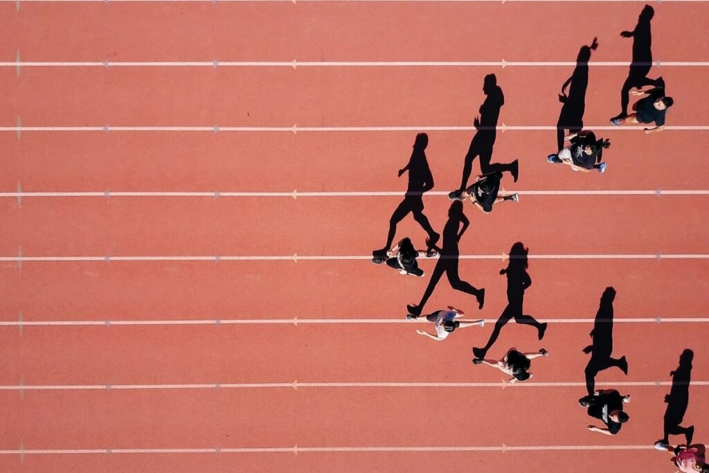 An aerial view of people running on a track in a V formation, suggesting a united, group effort.
