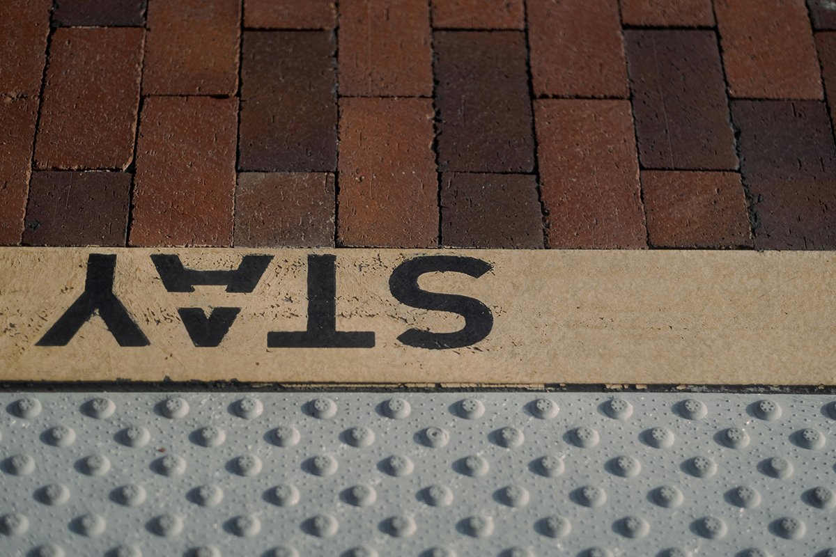 The word “STAY” painted onto a sidewalk at a boundary.