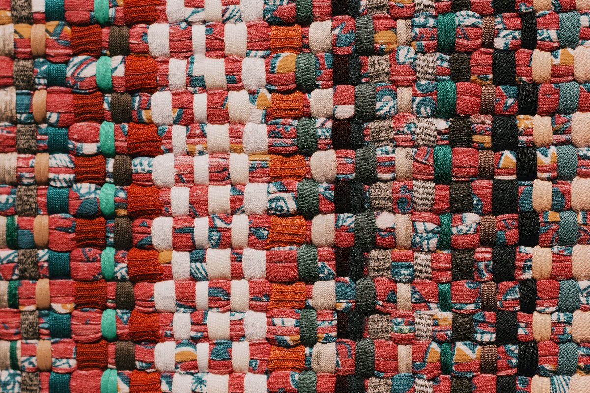 A colorful textile made of woven pieces threaded through each other.