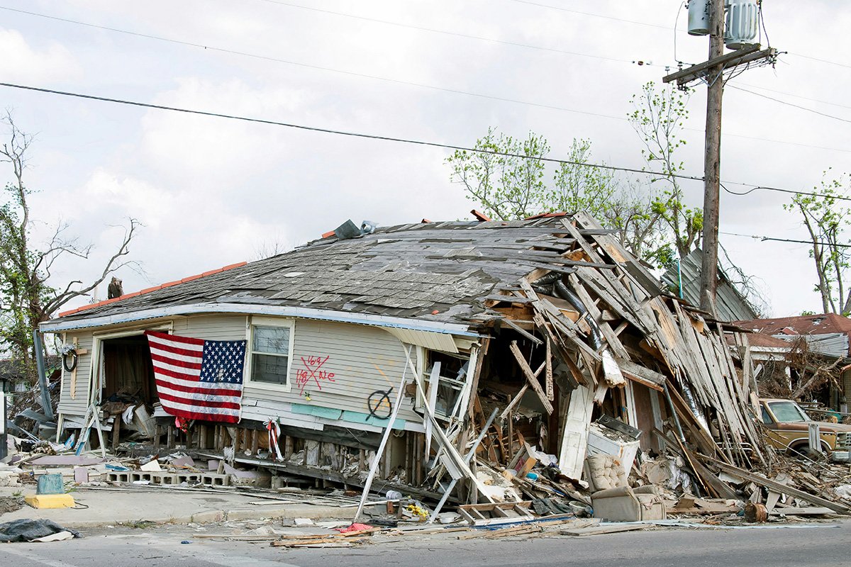 A hurricane-ravaged wooden house in New Orleans, with wooden boards, furniture, and applicanes scattered over the street. Ninth Ward, New Orleans, Louisiana.