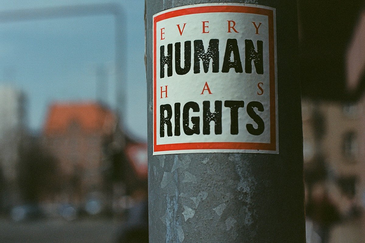 A sign plastered to a pole reading, “Every Human has Rights.”