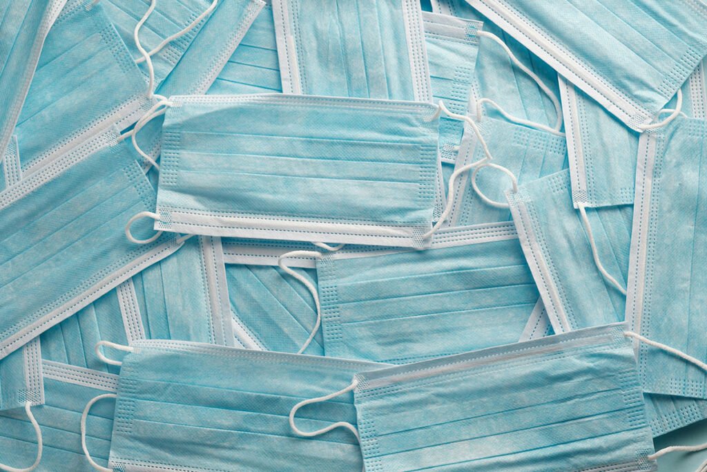 A pile of disposable blue respiratory face masks.