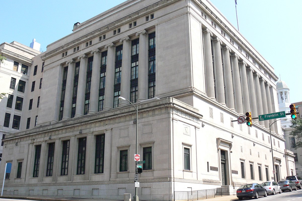 The The Supreme Court building in Richmond, VA, a serioud-looking gray stone building with columns.