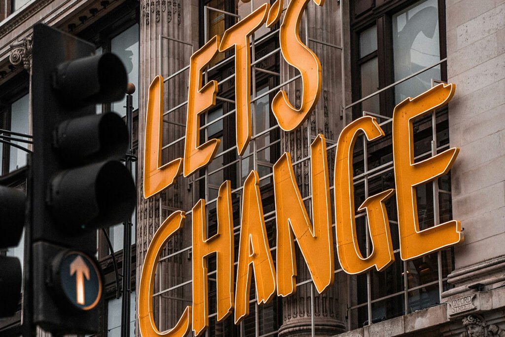 A sign on the side of a building reading, “Let’s Change”