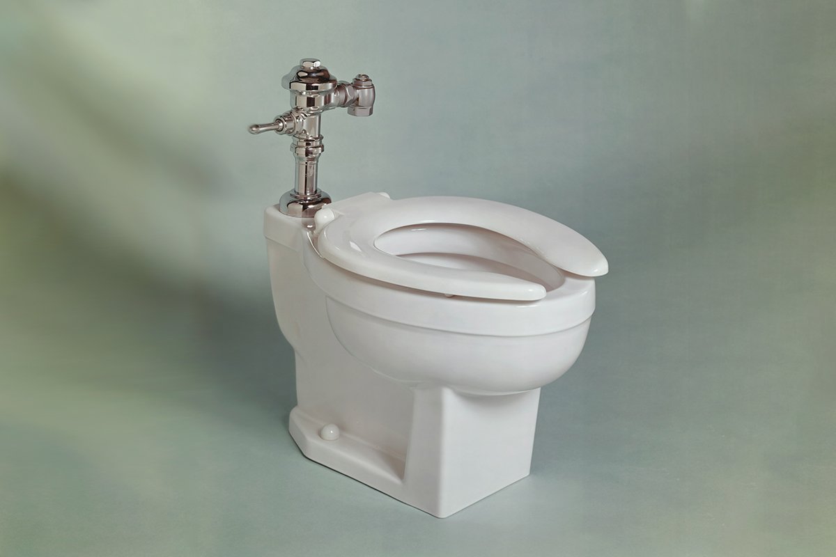 A solitary white toilet in an empty room.