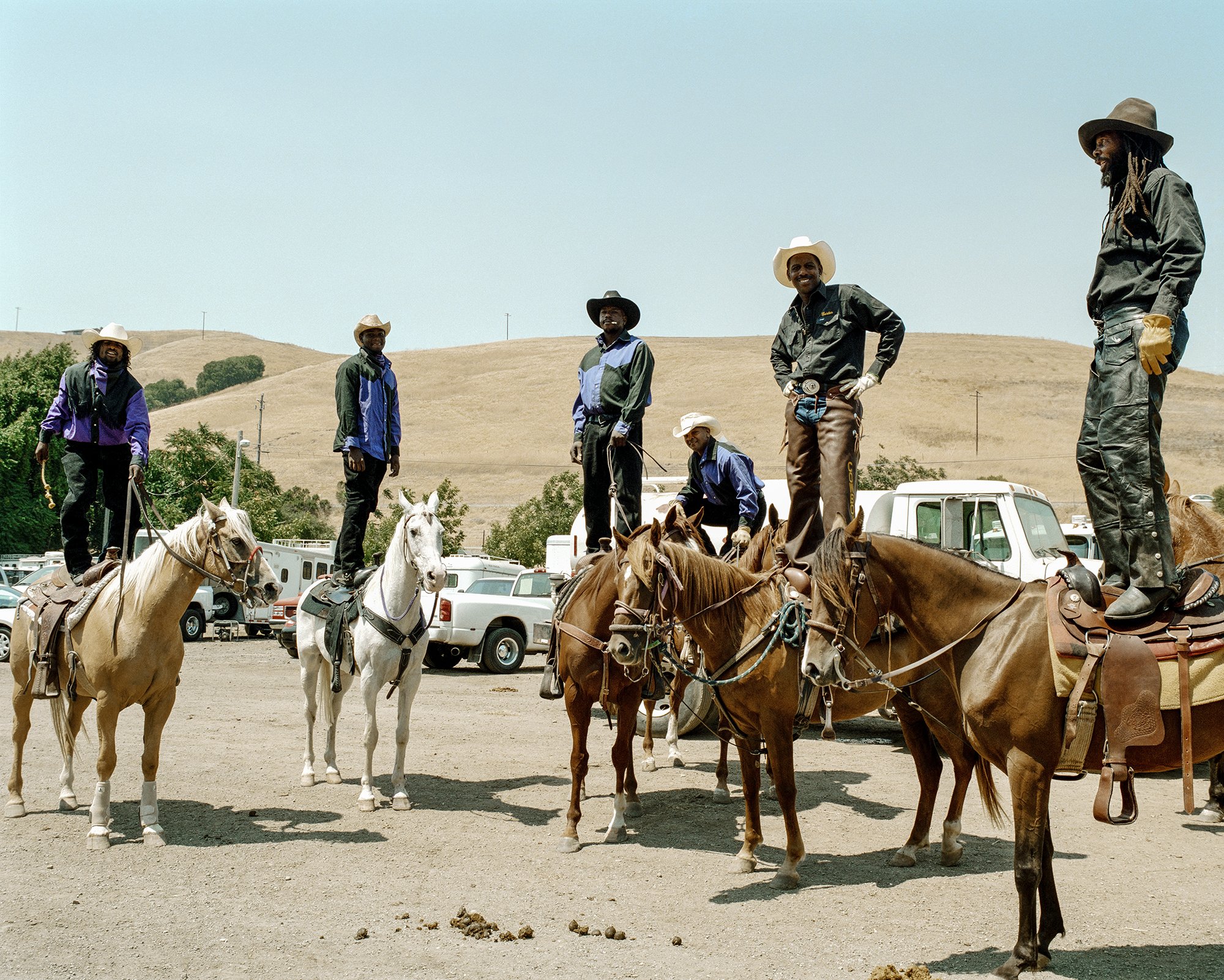 Bill Pickett Invitational Rodeo, Oakland, California 2008. Joseph “Dugga” Matthews (far right) stands on his horse in 2018 with a group of riders from Stockton, California, who are part of the Brotherhood Riders group. Dugga is a horse trainer, farrier, and veterinarian. He came to the States from Antigua in 1998, and has been attending the BPIR ever since. Photograph by Gabriela Hasbun.