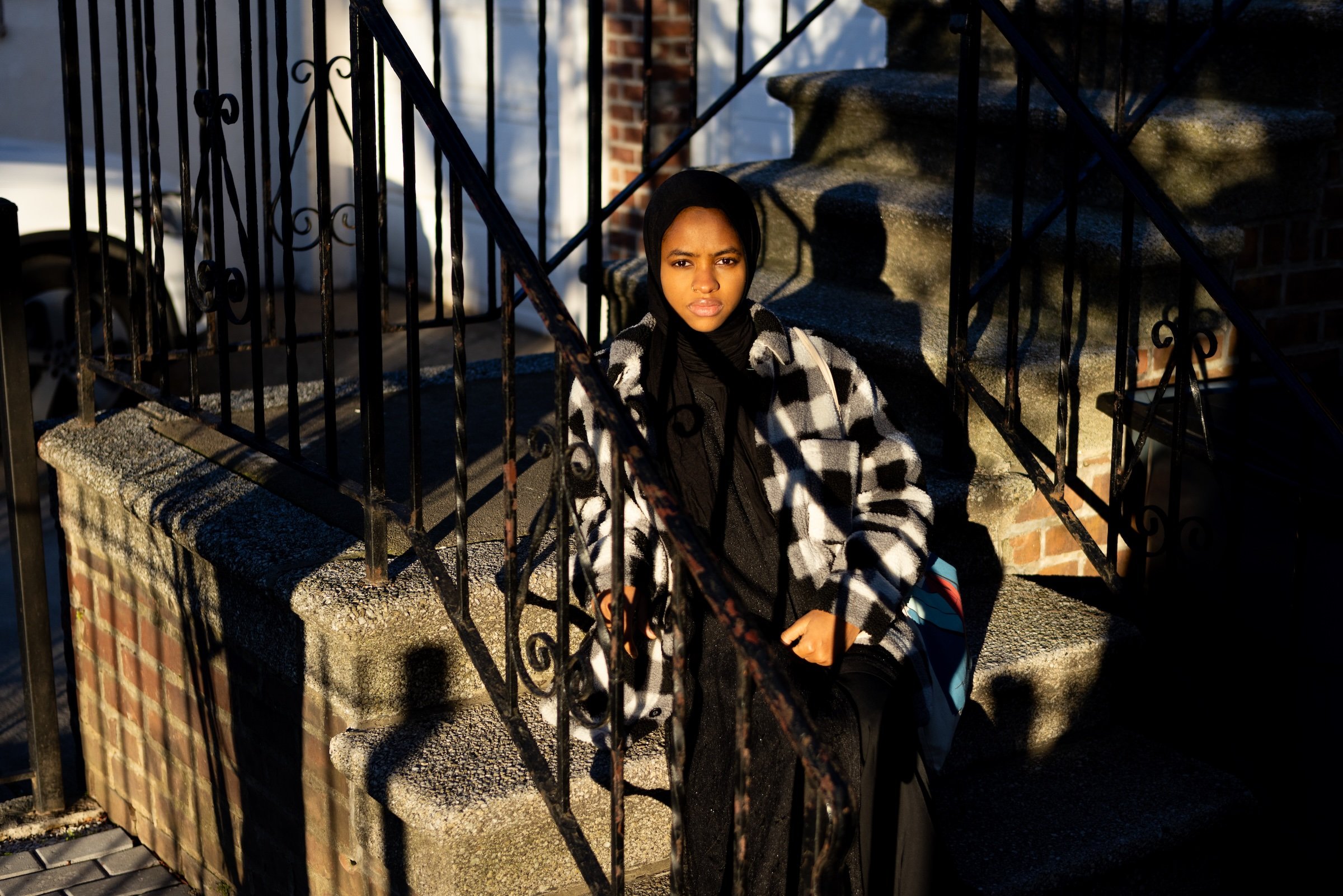 Environmental justice | American Muslim Experience documentaryKadjahtou, outside in the stoop of her Bronx house. She started a Muslim-led environmental justice resource center and is currently working on starting a non-profit to help deal with the massive amounts of "fast-fashion" clothes that ends up in the trash. Photography by Syed Yaqeen.