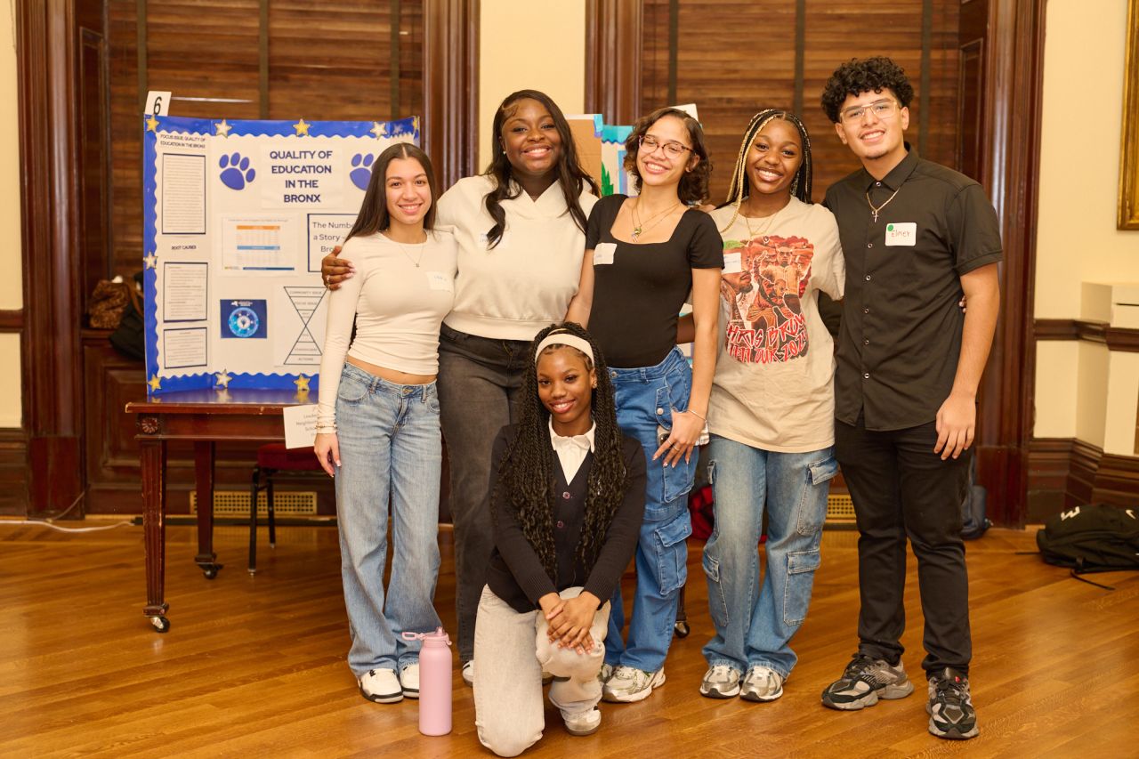 Photo of Generation Citizen students posing in a classroom in front of their presentations.