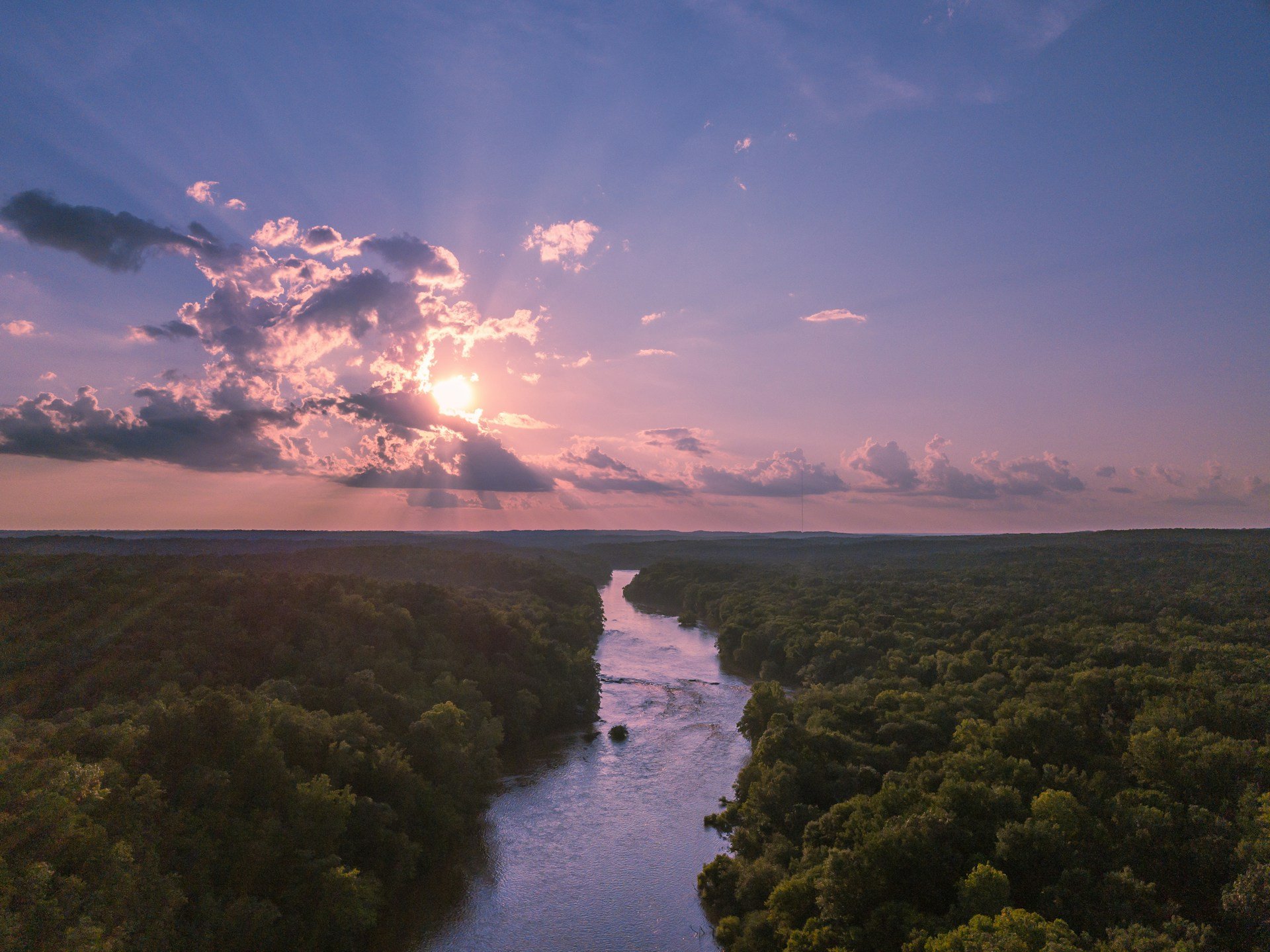 Aerial view of an expansive forest of North Carolina, with a river winding through the middle.