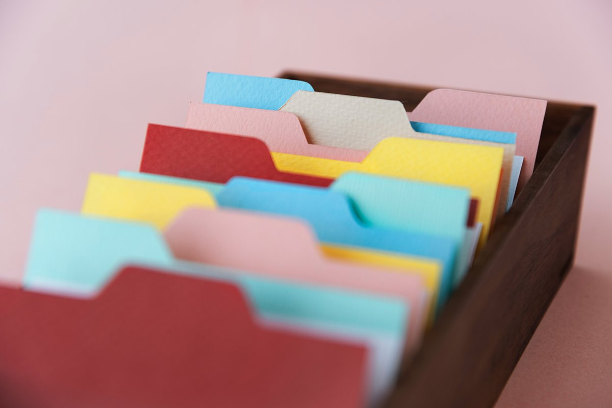 A close-up on file cabinet drawer containing colorful folders.