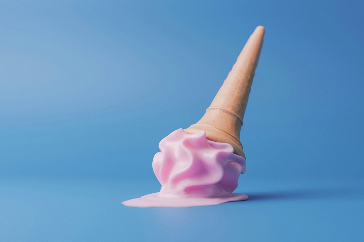 A pink swirly ice cream that has dropped onto the floor, landing sccop down and cone up. A puddle of melted ice cream pools around the scoop.